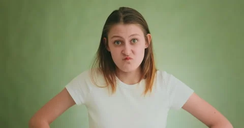 Funny lady in white clothes makes angry grimaces on green Видео 154711306