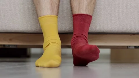 Funny legs in socks of different colors. Yellow and red socks. Stock Footage 279257181