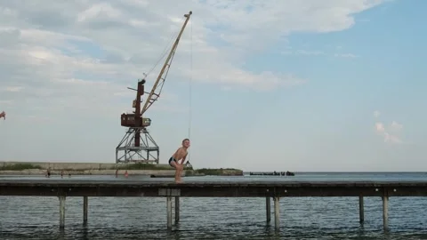Funny little boy dancing hip hop and posing on a wooden pier near the sea w.. Stock Footage 338197836