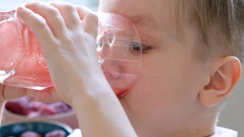 Funny little boy drinking fresh red juice and looking to camera with happy face Stock Footage 128393436