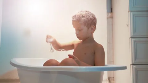 Funny little boy five year old sitting in the bathtub Stock Footage 255708677