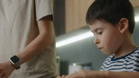 Funny little boy helper learning to knead dough with rolling pin in the kitchen Stock Footage 263683818