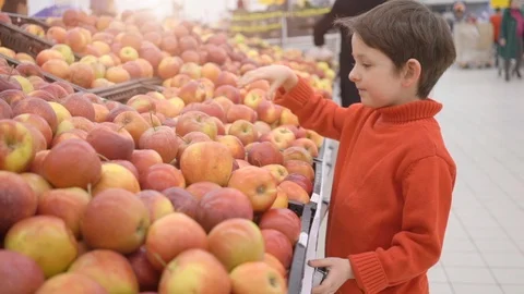 Funny little boy picking apple from the box, during family shopping in Stock Footage 105248254