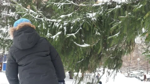 Funny little boy in winter clothes walks during a snowfall. Outdoors winter 库存影片 150520574