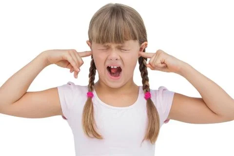 Funny little girl clogging her ears and wincing Stock Photos