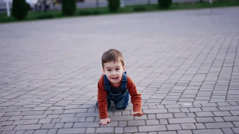 Funny little kid crawling by the paved ground outdoors. Stock Footage 276105589