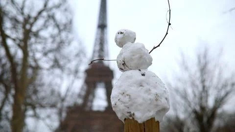 Funny little snowman and the Eiffel tower on a day with heavy snow Stock Footage 317102785