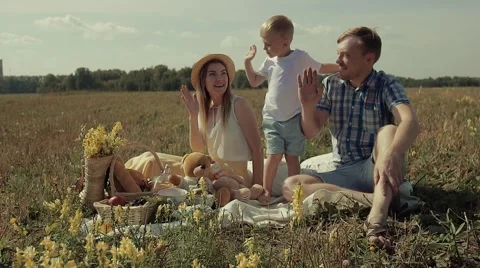 Funny little son gives his parents a five. They are smiling and laughing Stock Footage