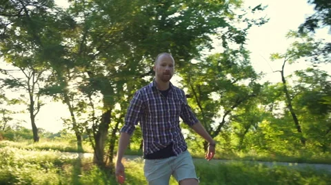 Funny male grimacing while riding longboard in park slow motion Video stock 64447827