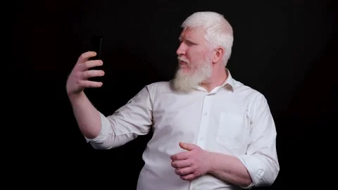 Funny man with albinism using phone and taking selfie on black background. Stock Footage 142215523