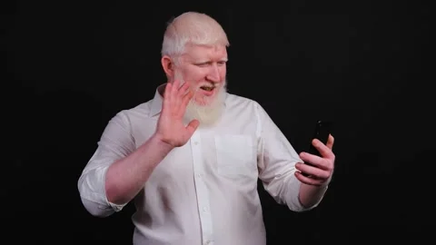 Funny man with albinism using phone and talking online on black background. Stock Footage 144385237