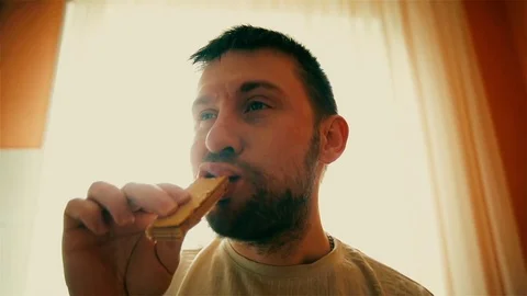 Funny man with beard and mustache with an appetite is eating waffle cake Stock Footage 73497443