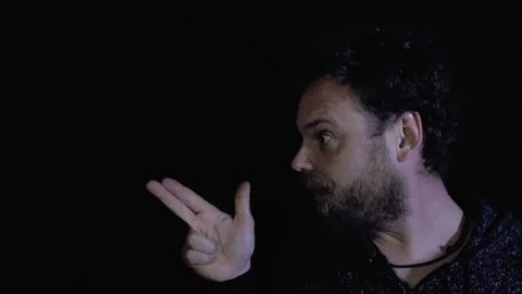 Funny man with a beard and mustache shoots a finger over black background Stock Footage 105464877