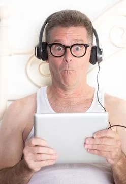 Funny Man in Bed with Computer Tablet Stock Photos
