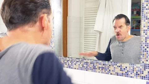Funny man combing hair dancing funny in front of mirror closeup Stock Footage 82359438