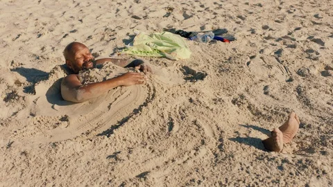 Funny man covered in sand on beach enjoying summertime having fun relaxing on Stock Footage 110619699