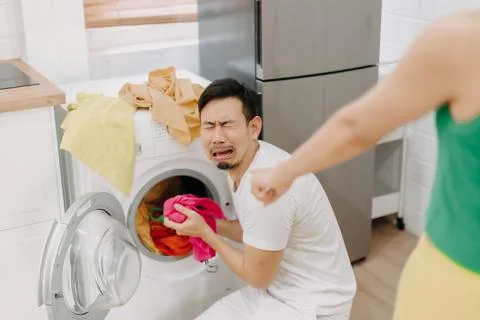 Funny man crying being force by his wife to wash clothes and do housework. Stock Photos