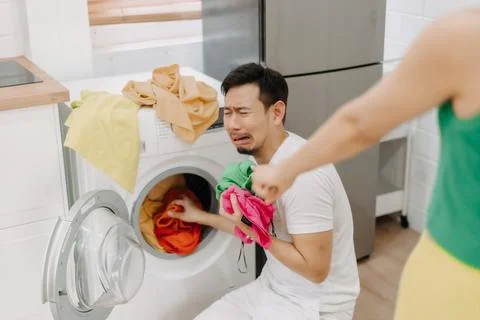 Funny man crying being force by his wife to wash clothes and do housework. Stock-Fotos