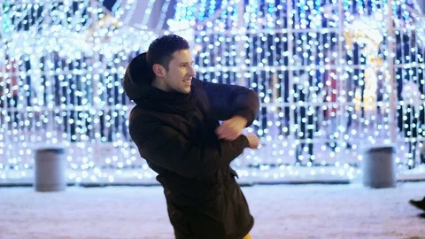 Funny man dancing at a party to the new year on the city Christmas tree Stock Footage 100464546