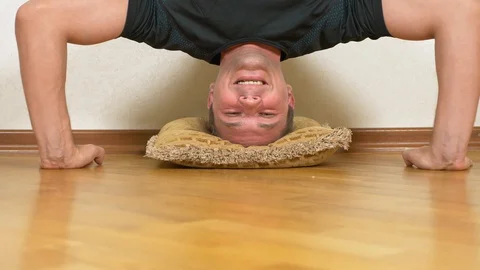 A funny man does upside down pushups in the house. 4k, shooting dolly Video stock 88987544