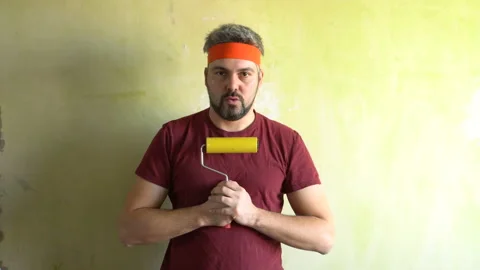 Funny man doing breathing exercises with wallpaper roll 4K Stock-Footage 126125977