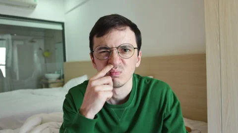 Funny man with glasses picking his nose and looking at his finger Video stock 337366253