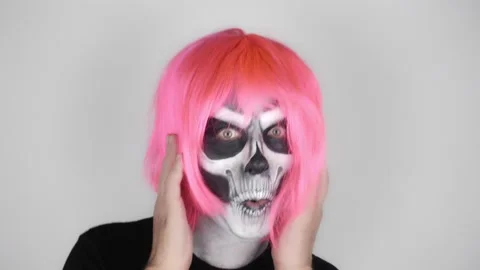 Funny man in halloween skeleton make-up in pink wig flaunts in front of camera Vídeo Stock 139289819