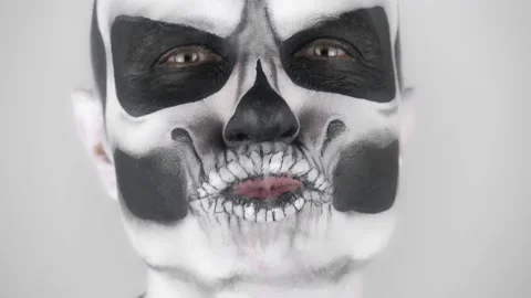 Funny man in Halloween skeleton make-up kisses and smiles for the camera Vídeo Stock 139291853