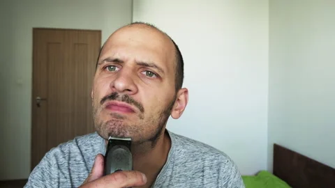 Funny man himself cuts his beard with trim Stock Footage 223558512