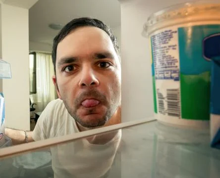 Funny man looking into the fridge Stock Photos
