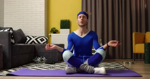Funny Man Meditating practicing Yoga exercise sitting on Fitness mat at home Video stock 153682088