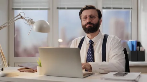 Funny man office worker performs task. Funny grimacing worker typing text on Stock-Footage 265944833