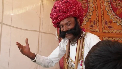 Funny man from Rajasthan with big moustache dancing with a kid Stock Footage 69768043