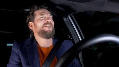 Funny man singing and dancing at night while driving car Stock Footage 73158855