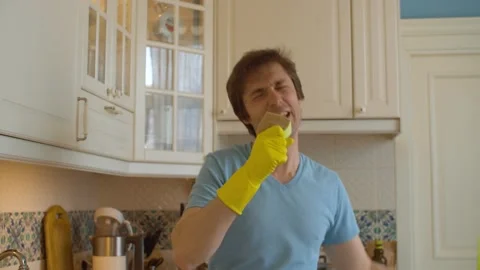 Funny man singing and dancing in the kitchen Stock Footage 131068653