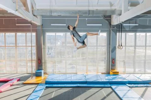 Funny man trying to touch ceiling during the jumping Stock Photos