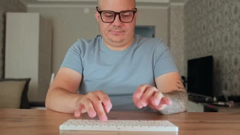 Funny man typing fast on the keyboard while working at home Stock Footage 246002988
