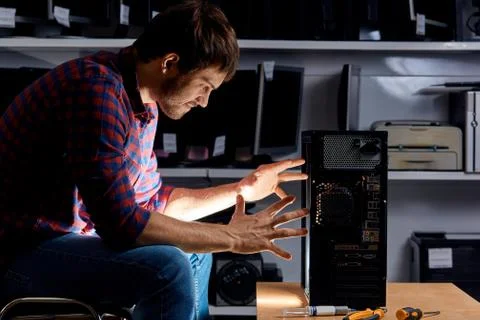 Funny man using magic skills while repairing a computer Stock Photos