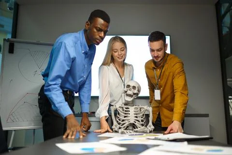 Funny managers and skeleton in IT office, joke Stock Photos