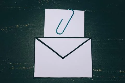Funny metaphor of inbox with email envelop and attachment clip on real-life d Stock Photos