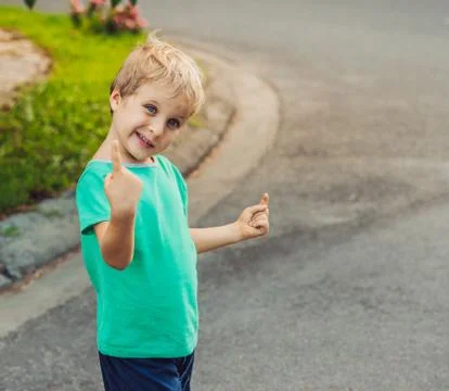 Funny mischievous cute boy make freckled face playing outside, laughing, show Stock Photos