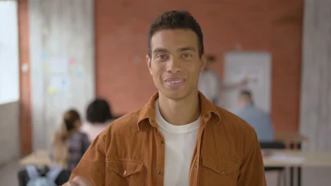 Funny mixed-race guy happy smiling to the camera. Pupil student shows thumb up Stock Footage 107743888