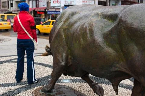 Funny moment of young woman and bull statue at Kadikoy Stock Photos