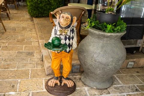 Funny monkey statue outside a cafe. Humor, street decor, and quirky visual .. Stock Photos