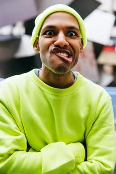 Funny multiracial man making exaggerated face in urban street Stock Photos