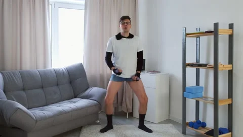 Funny nerd man in glasses is doing fitness exercises for hands with dumbbells. Video stock 153257469