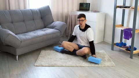 Funny nerd man in glasses is doing fitness exercises for hands with soft blocks. Stock Footage 158167152