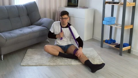 Funny nerd man in glasses doing fitness exercise for neck usind resistance band. Stock Footage 158428483