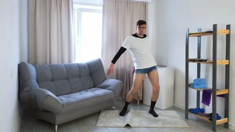 Funny nerd young man in glasses is performing backpack kid dance at home. Video stock 153260979