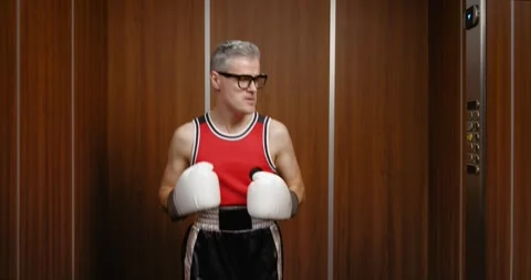 Funny nerdy boxer taking an elevator Stock Footage 308919471